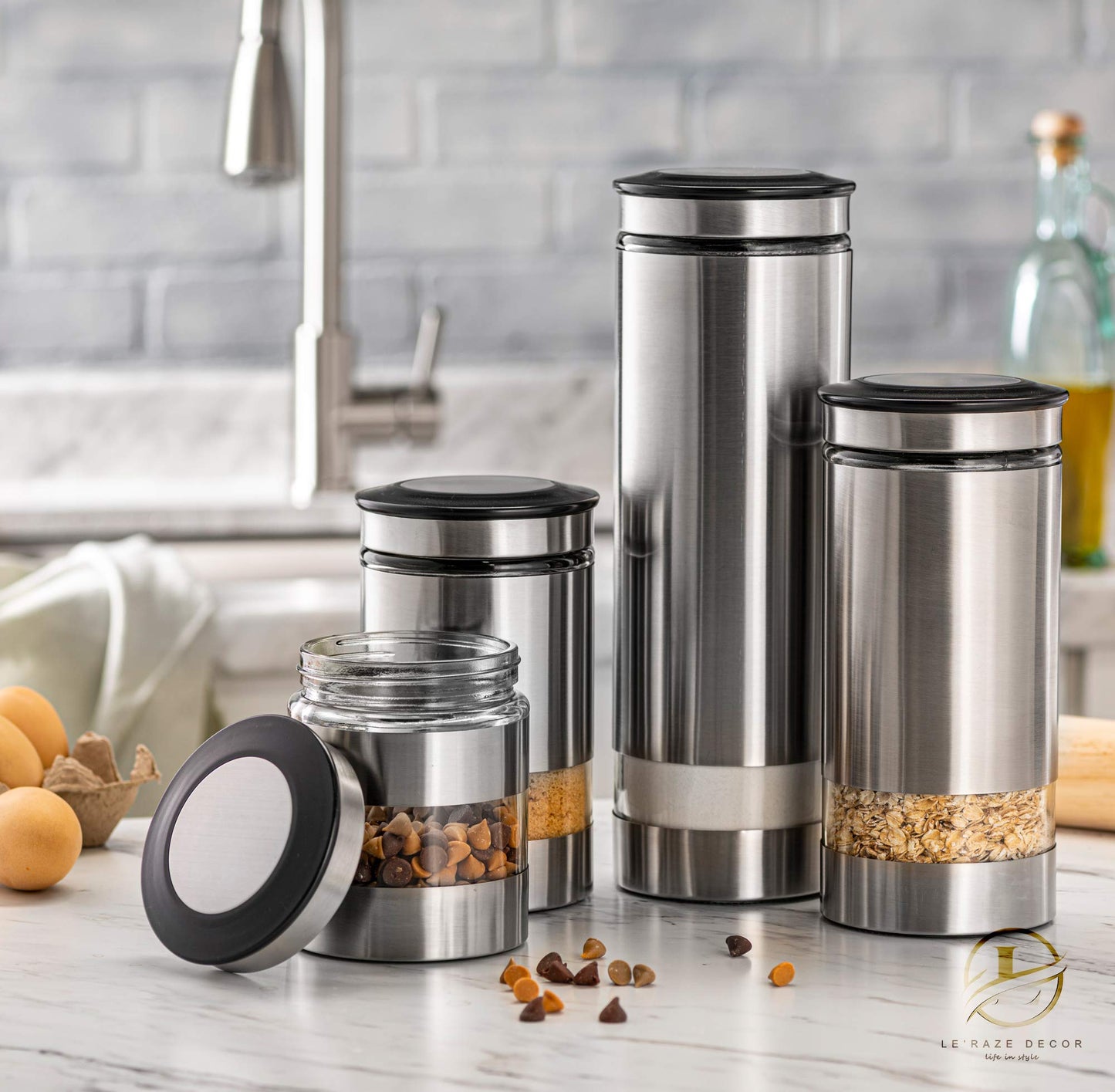 Le'raze Airtight Glass Canister Set of 4 with Stainless Steel Sleeve for Kitchen Counter - Food Storage Containers with Glass Window and Airtight Lids - Pantry Storage and Organization Set
